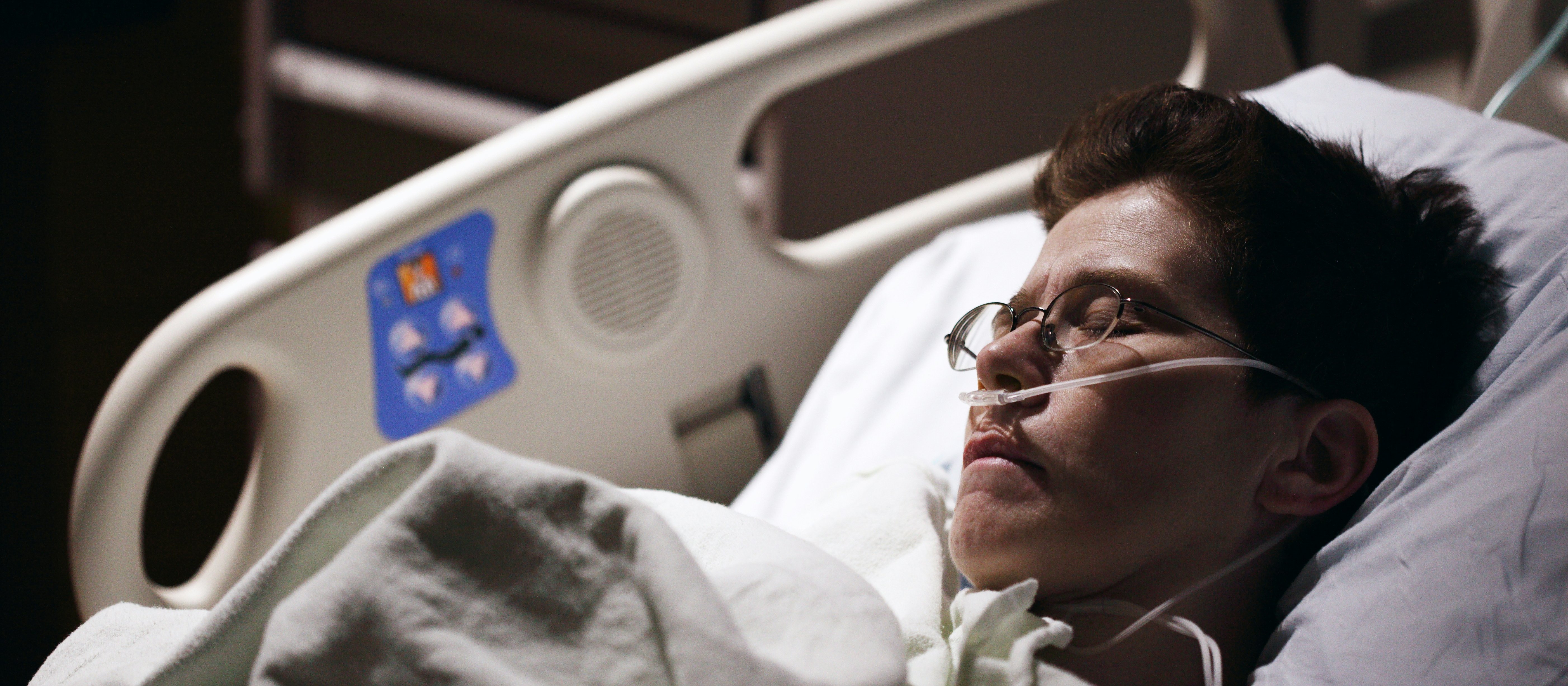 Man with glasses in hospital bed