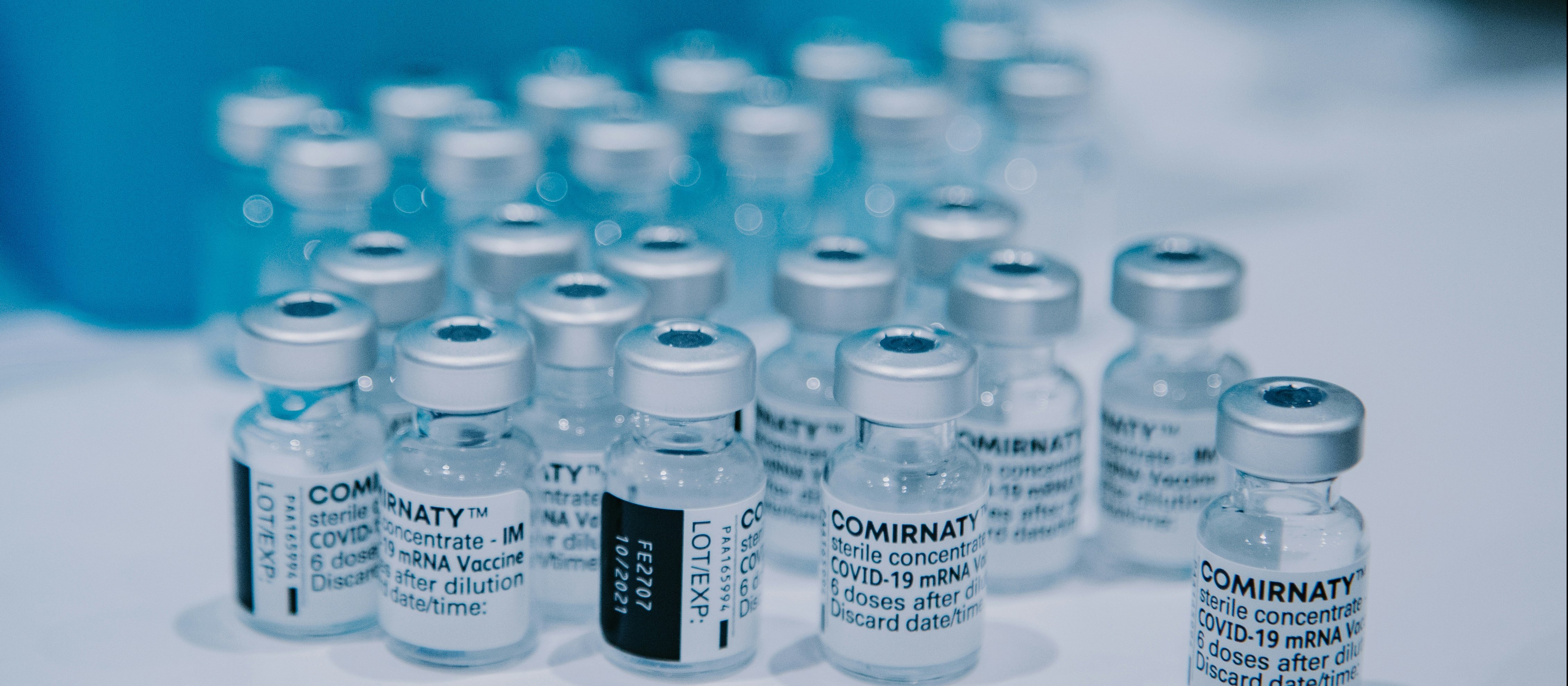 Vials of Comirnaty covid-19 vaccines sitting on a white bench