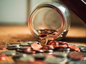 Coins spilling out of a clear jar